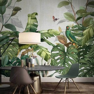 Puede incluir: Un comedor con un papel tapiz tropical con grandes hojas verdes, una l&aacute;mpara blanca, una mesa de madera oscura y dos sillas. El papel tapiz tiene un loro verde y una mariposa.