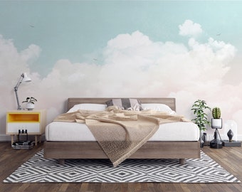 Puede incluir: Un dormitorio con una cama de estructura de madera y un edredón blanco. La pared detrás de la cama tiene un mural pintado de un cielo azul con nubes blancas. Hay una pequeña mesita de noche de madera con una lámpara y una planta encima.