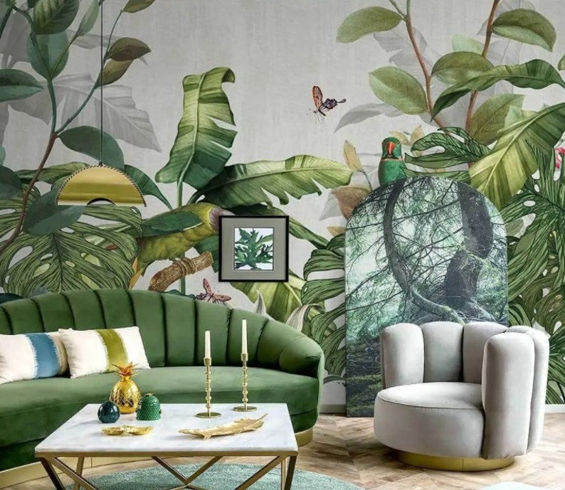Puede incluir: Un dise&ntilde;o de interior de sala de estar con un sof&aacute; de terciopelo verde, una mesa de caf&eacute; blanca, un sill&oacute;n gris y un papel tapiz tropical con hojas verdes y un loro.