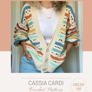 以下が含まれることがあります： クリーム色の、青、オレンジ、ティール色のカラフルなストライプが入ったかぎ針編みのカーディガン。オープンなデザインで、Vネックとボタン留めが特徴です。「Cassia Cardi Crochet Pattern」の文字が下に表示されています。
