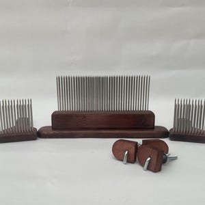 May include: A collection of wooden fiber combs and accessories. The combs feature a dark brown wooden base with many metal tines. The set includes three combs of different sizes and three wooden knobs with metal hooks.