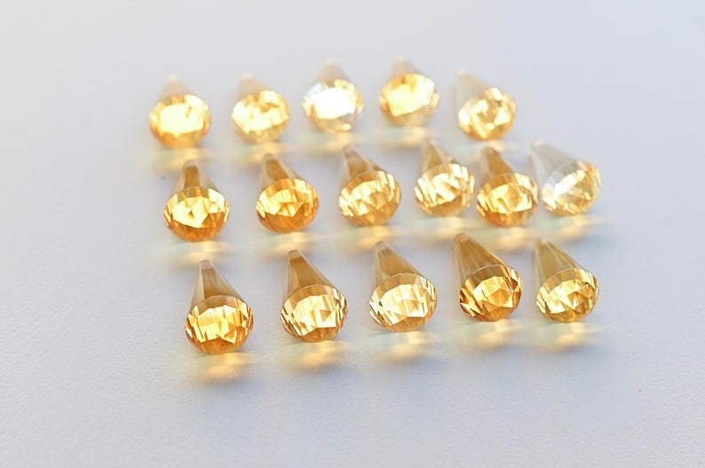 Puede incluir: Una colecci&oacute;n de 18 cristales facetados en forma de l&aacute;grima en tonos &aacute;mbar y dorado.