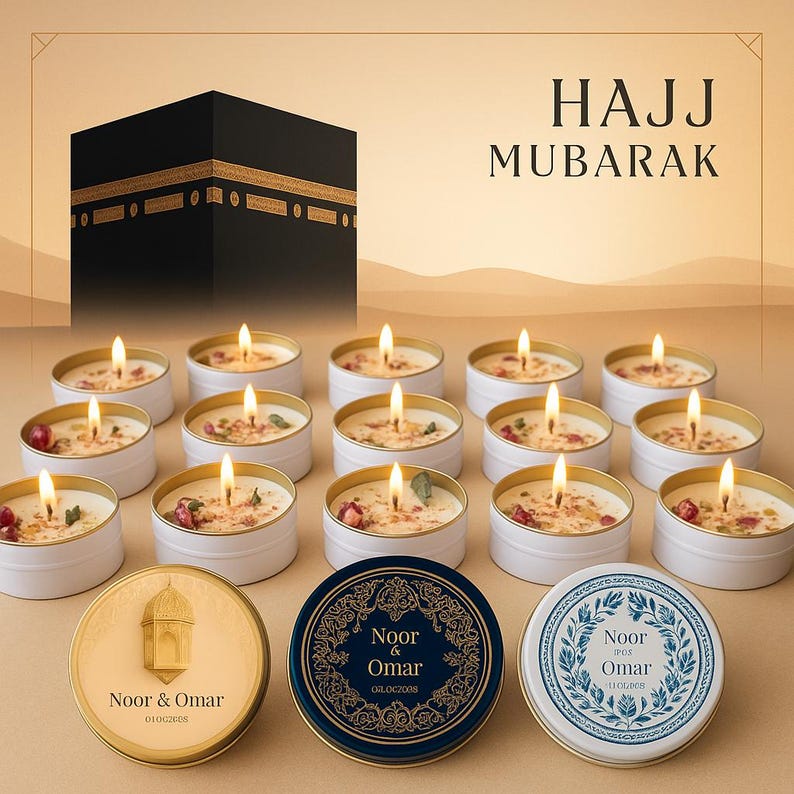 May include: A collection of lit candles in white tins, with a backdrop featuring a black structure and the words "HAJJ MUBARAK". The candles have a floral and spice arrangement on top, with three decorative tins in the foreground.