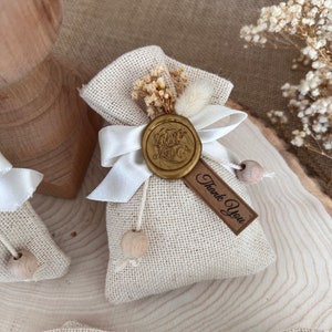 May include: A small burlap bag with a white ribbon and a gold wax seal that says "With Love". The bag has a small wooden tag that says "Thank You".