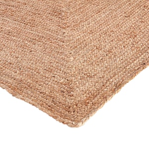 May include: A close-up of a natural fiber rug with a woven texture. The rug is a light brown color and has a slightly rough surface.