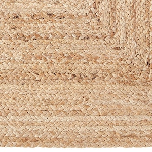 May include: A close-up of a natural fibre rug with a woven texture. The rug is made of jute and has a light brown colour.