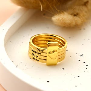 May include: A white ceramic mug with a black handle and the text "But First, Coffee" in a bold, black font. The mug is set against a neutral background, highlighting its simple design.