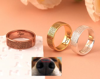 May include: Three personalized rings with textured surfaces. The rings are engraved with the names "Tiger", "Doris", and "Lucy".