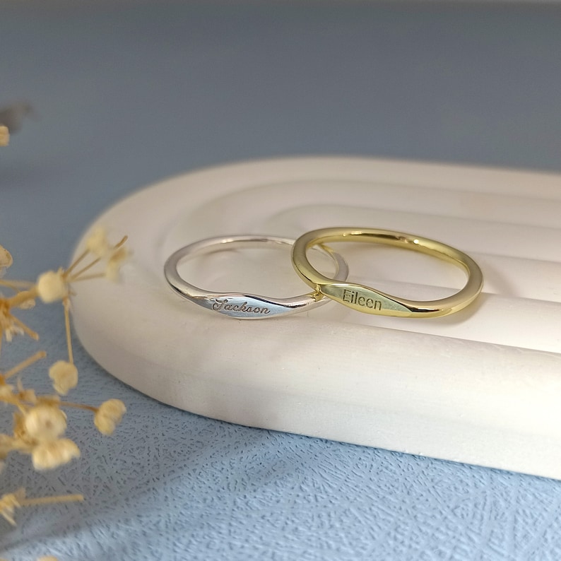 May include: Two thin gold and silver rings with the names "Eileen" and "Jackson" engraved on them.