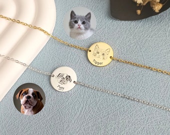 Puede incluir: Dos pulseras delicadas, una dorada y otra plateada, cada una con un colgante circular con un retrato de mascota. La pulsera dorada tiene un retrato de gato con el nombre "Tigger". La pulsera plateada tiene un retrato de perro con el nombre "Poffy".