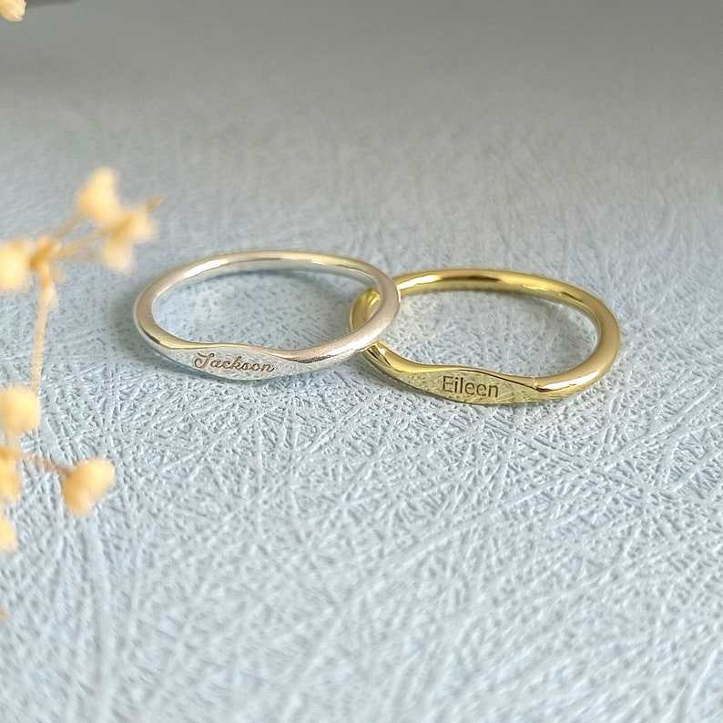 May include: Two personalized rings, one silver and one gold, with the names "Jackson" and "Eileen" engraved on them.