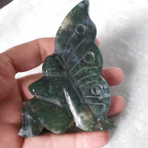 May include: Green agate butterfly figurine with detailed wings. The figurine is carved from a green stone with white and grey markings.