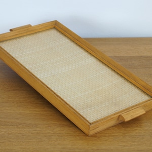 May include: A rectangular wooden tray with a woven insert. The tray has two small handles on the sides.
