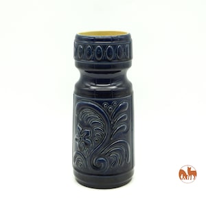 Könnte beinhalten: Eine dunkelblaue Keramikvase mit einem aufwendigen Blumendesign. Die Vase hat eine strukturierte Oberfläche und einen leicht ausgestellten oberen Rand.