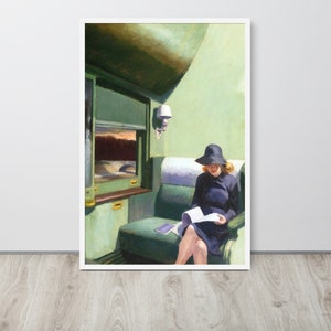 May include: A woman in a black hat and dress sits on a green train seat reading a book. The train window is visible behind her, showing a view of a forest and a sunset.