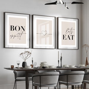 May include: A dining room with a wooden table and six grey chairs. Three framed prints hang on the wall above the table. The prints feature the text "Bon appetit", a heart, and "Let's Eat".