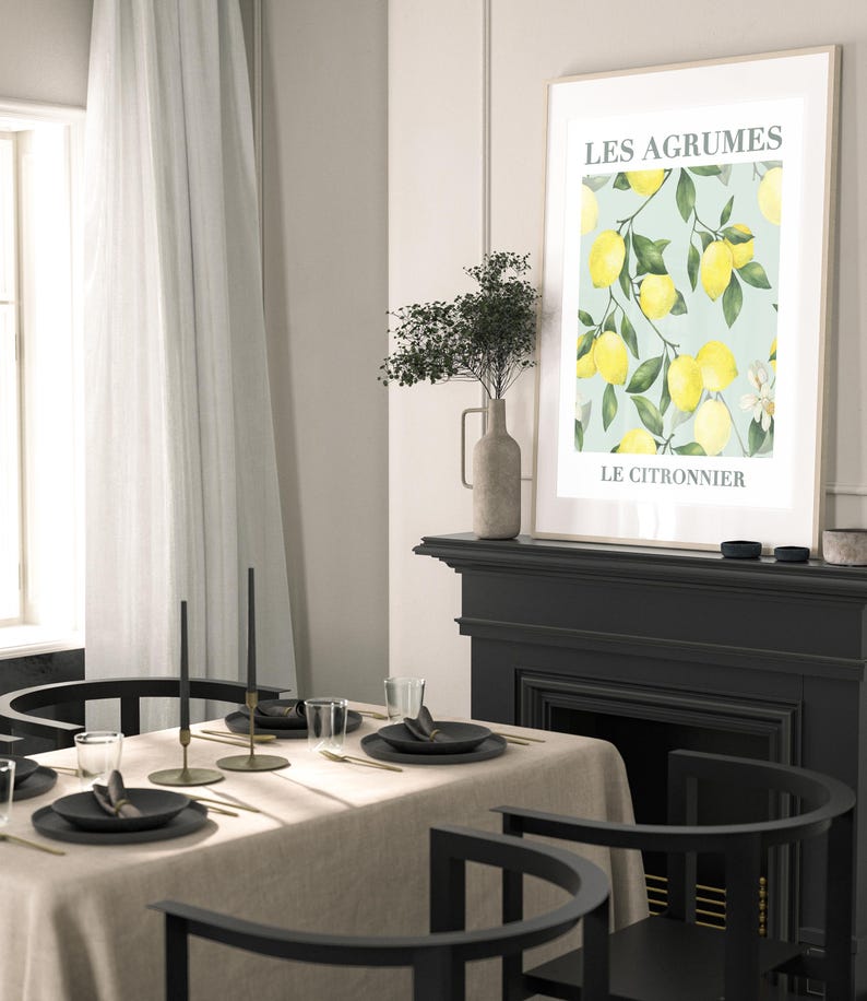 May include: A black and white illustration of lemons on a branch with the text "LES AGRUMES LE CITRONNIER" on a light blue background. The illustration is framed and hanging on a wall above a black fireplace.