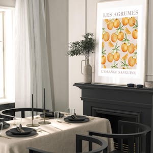 May include: A black and white print with a graphic of oranges and leaves. The print has the text "Les Agrumes L'Orange Sanguine" in white.