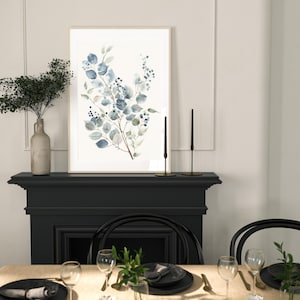 May include: A framed watercolour painting of a blue and green floral arrangement with a black fireplace and dining table setting in the background.