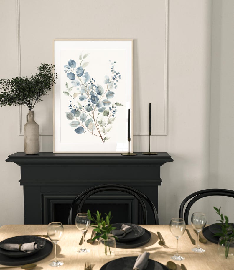May include: A framed watercolour painting of a blue and green floral arrangement with a black fireplace and dining table setting in the background.