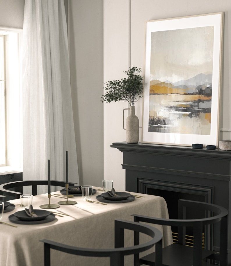 May include: A dining room table setting with a beige linen tablecloth, black chairs, and gold flatware. Two black candlesticks with black candles are on the table. A framed abstract landscape painting hangs above a black fireplace.