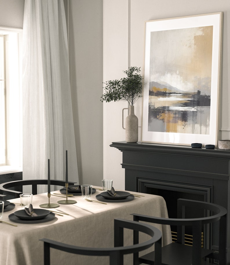 May include: A dining room table setting with a beige linen tablecloth, black chairs, and gold flatware. Two black candlesticks with black candles are on the table. A framed abstract landscape painting hangs above a black fireplace.