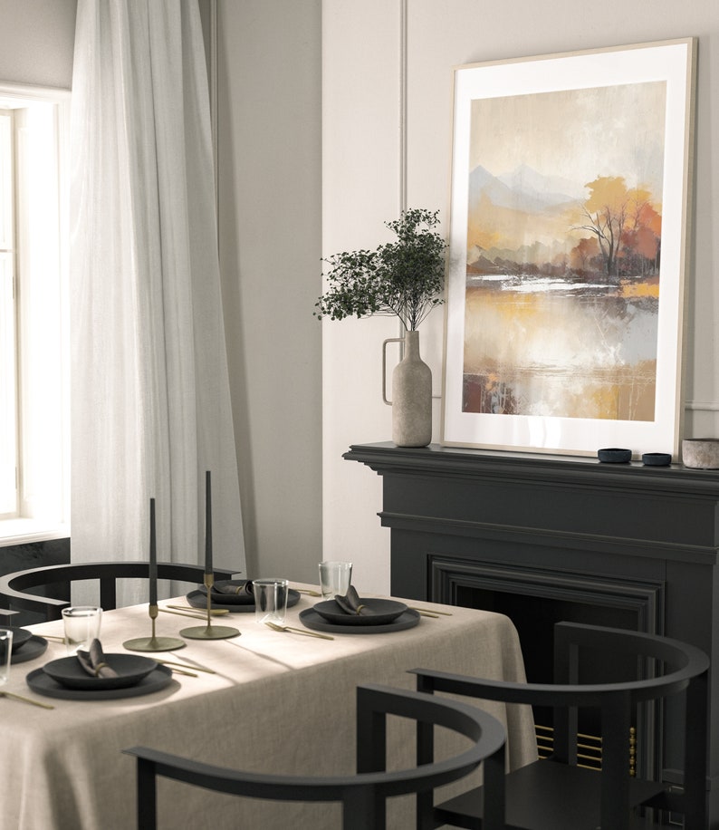 May include: A dining room table setting with a beige linen tablecloth, black chairs, and gold flatware. Two black candlesticks with black candles are on the table. A framed abstract landscape painting hangs above a black fireplace.