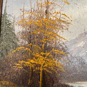 May include: Oil painting of a landscape featuring a tree with bright yellow leaves in the foreground. The tree's trunk and branches are a light brown color. The background includes a forest, a body of water, and a mountain range.