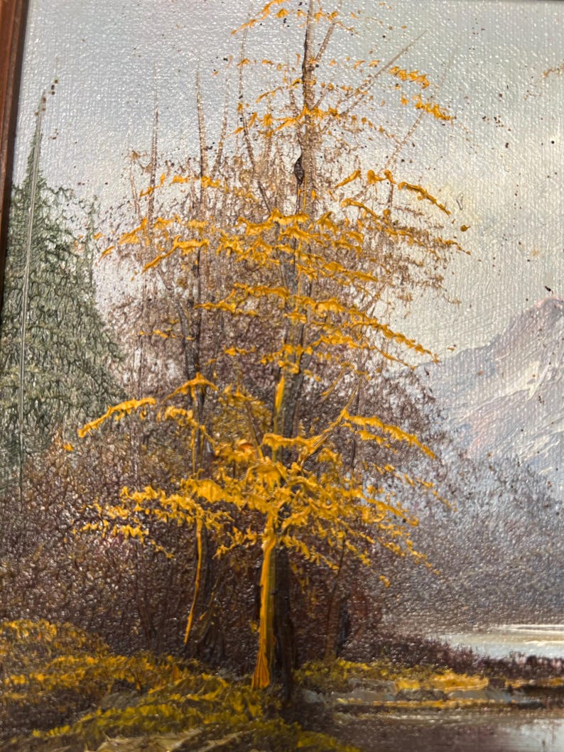 May include: Oil painting of a landscape featuring a tree with bright yellow leaves in the foreground. The tree's trunk and branches are a light brown color. The background includes a forest, a body of water, and a mountain range.