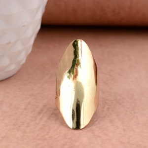 Könnte beinhalten: Ein goldfarbener, ovaler Ring mit glatter, polierter Oberfläche.