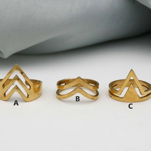 Könnte beinhalten: Drei goldfarbene Ringe mit geometrischen Designs. Die Ringe sind mit A, B und C gekennzeichnet.