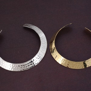 May include: Two hammered metal choker necklaces, one silver and one gold.