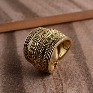Peut inclure: Une bague en or avec un motif g&eacute;om&eacute;trique complexe. La bague est large et l&eacute;g&egrave;rement arrondie.