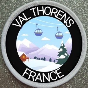 May include: A white and black circular patch with the text "Val Thorens France" and a cartoon image of a snowy mountain scene with ski lifts and a small cabin.
