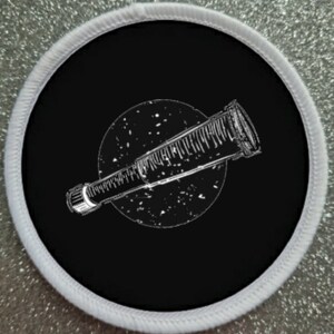 May include: A black and white illustration of a telescope pointed towards a starry sky. The telescope is surrounded by a circle of stars. The image is on a black background with a white border.