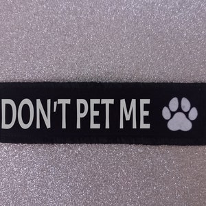 May include: Black fabric patch with white text that reads "DON'T PET ME" and a white paw print.