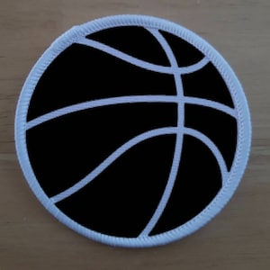 May include: A black basketball patch with white stitching around the edge.