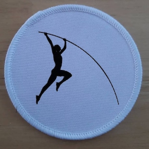 Puede incluir: Parche redondo blanco con una silueta negra de una persona saltando con pértiga.