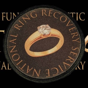 May include: A black and gold patch with the text "National Ring Recovery Service" and a gold ring with a diamond on a black background. The text "Raising Funds for Cystic Fibrosis UK" is also visible.