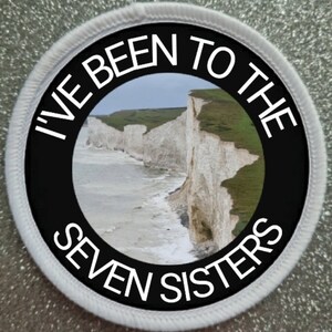May include: A white and black round patch with the text "I've Been To The Seven Sisters" in white lettering around a photo of white cliffs and a blue ocean.