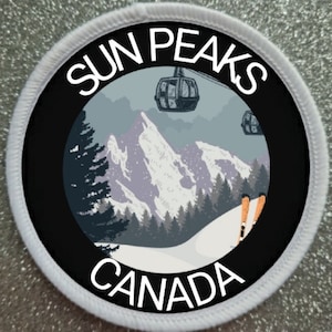 Puede incluir: Un parche redondo blanco con texto negro y un círculo negro en el centro. El texto dice "Sun Peaks Canada". El círculo contiene una escena de montaña nevada con un telesilla y esquiadores.