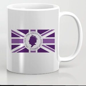 Könnte beinhalten: Weiße Keramiktasse mit einem violetten Union-Jack-Flaggenmuster. Die Flagge hat einen Kreis in der Mitte mit dem Text "The Queen's Platinum Jubilee 1952-2022" und eine Silhouette des Profils der Königin.