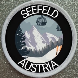 Könnte beinhalten: Ein runder weißer und schwarzer Patch mit dem Text "SEEFELD AUSTRIA" in weiß. Der Patch zeigt eine verschneite Berglandschaft mit einem Skilift und Skifahrern.