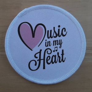 May include: White round fabric patch with a pink heart and the text "Music in my Heart" with musical notes.