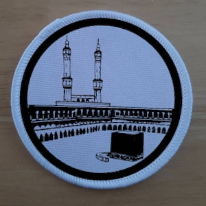 Puede incluir: Parche bordado en blanco y negro que representa la Kaaba en La Meca, Arabia Saudita. El parche presenta dos minaretes y una ilustración detallada de la Kaaba.