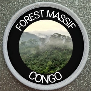 May include: A white and black circular patch with the text "FOREST MASSIF CONGO" in white lettering. The patch features a photo of a lush green forest with fog in the background.
