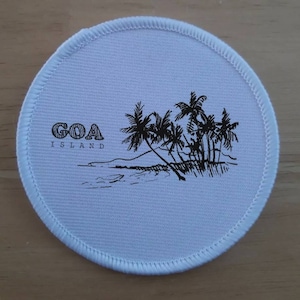 Puede incluir: Parche redondo de tela blanca con texto negro y una ilustración en blanco y negro de palmeras en una playa. El texto dice "GOA ISLAND".