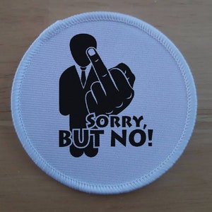 May include: White round patch with a black silhouette of a person giving the middle finger and the text "SORRY, BUT NO!"