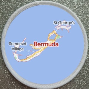May include: A white circular patch with a blue background showing a map of Bermuda with the text "Bermuda", "Somerset Village", and "St. George's" labeled.