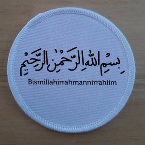 Puede incluir: Parche redondo de tela blanca con caligrafía árabe negra y el texto "Bismillahirrahmanirrahim" en inglés.